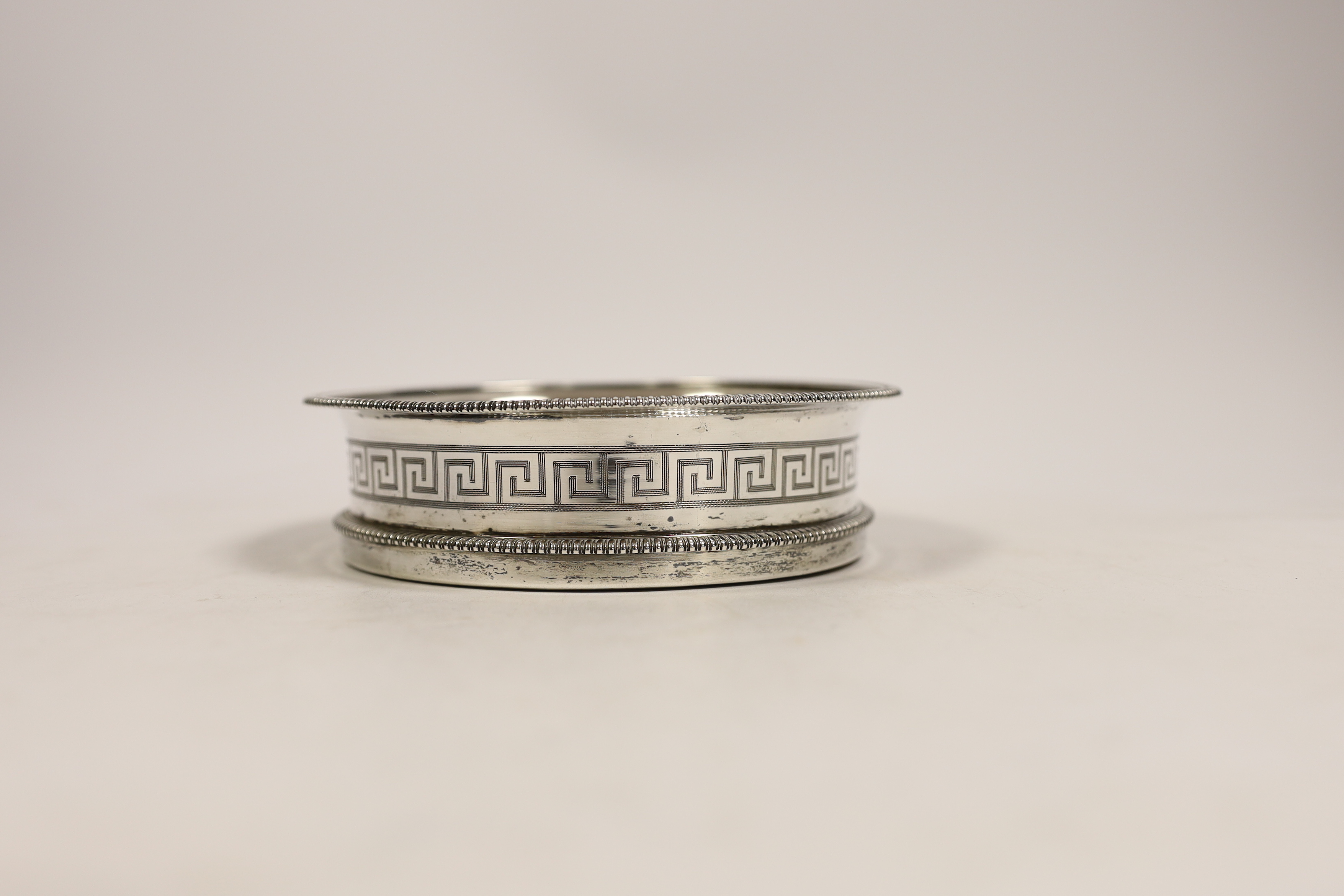 A George III silver mounted wine coaster, with gadrooned border and engraved Greek Key decoration, John Eames, London, 1806, 14.8cm.